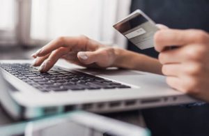 Person making an online payment using a credit card, demonstrating financial features of an association management system.