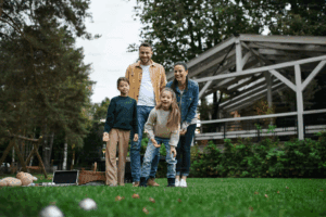A happy young family playing games during picnic outdoors in restaurant area
